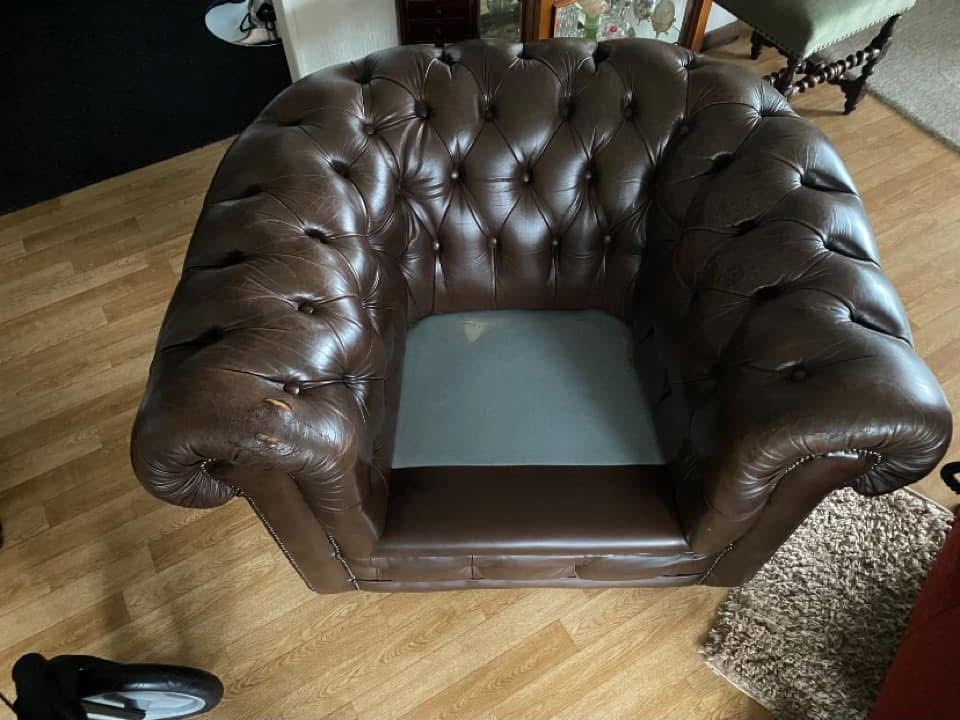 Versleten leren chesterfield voor renovatie