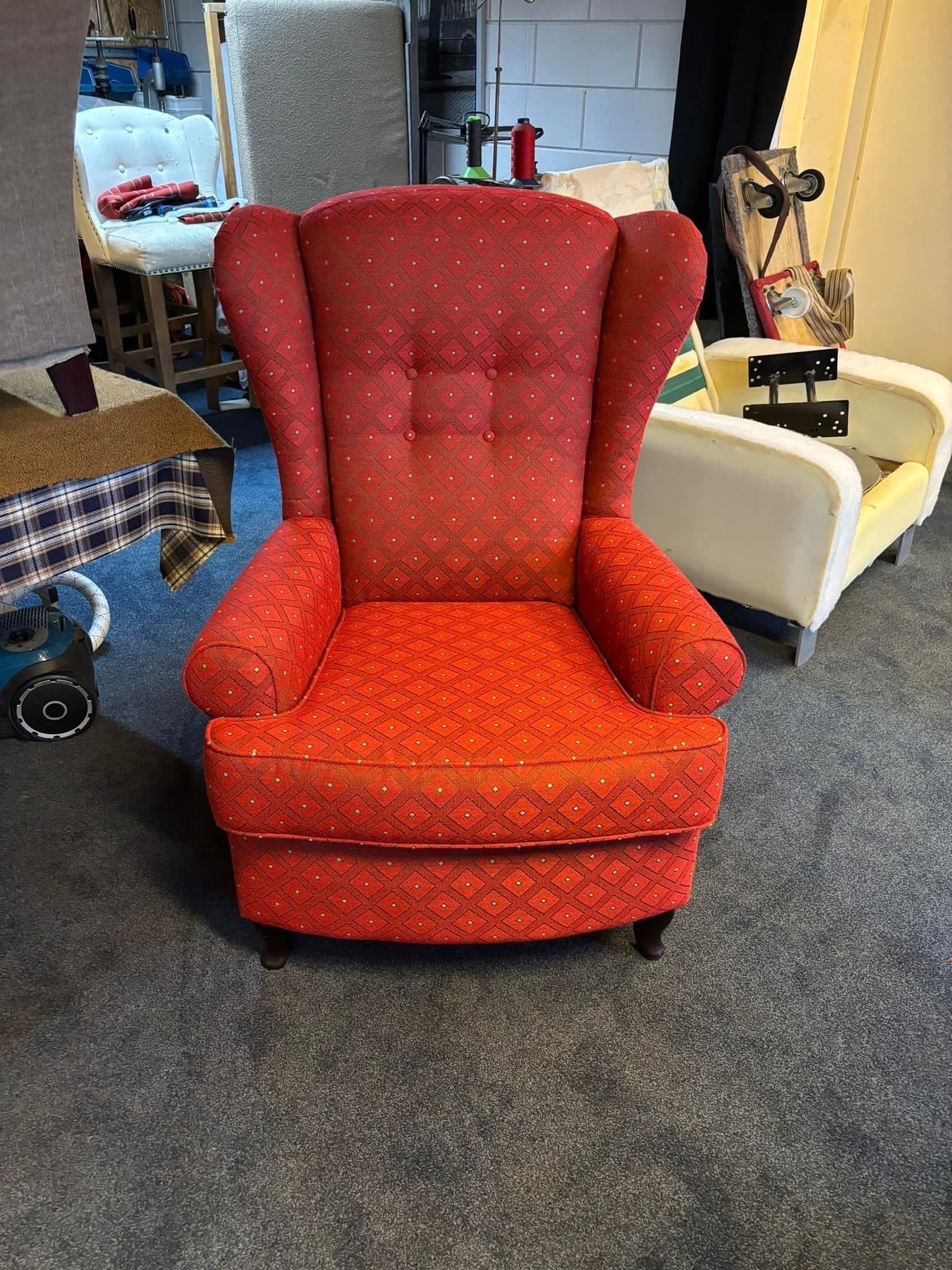 Dezelfde fauteuil na herstoffering in warm rood