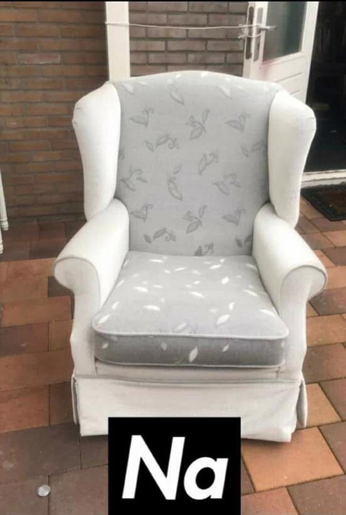 Dezelfde oorfauteuil na herstoffering in lichte stof