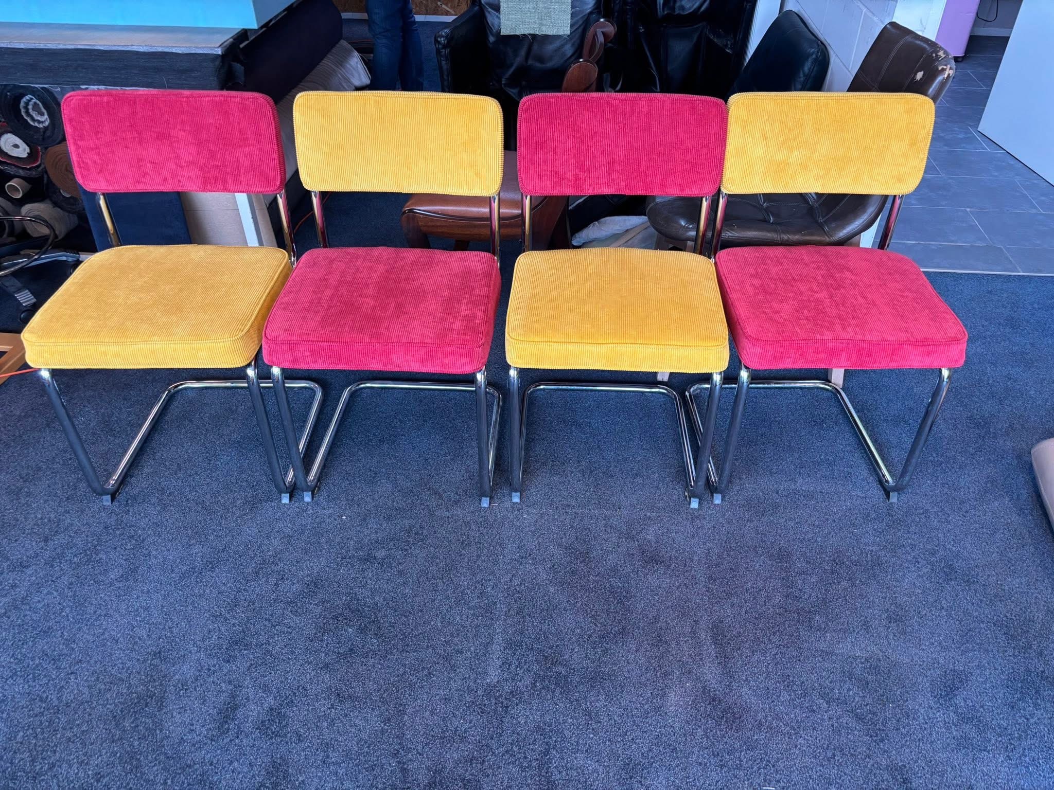 Vier retro stoelen in roze en okergeel